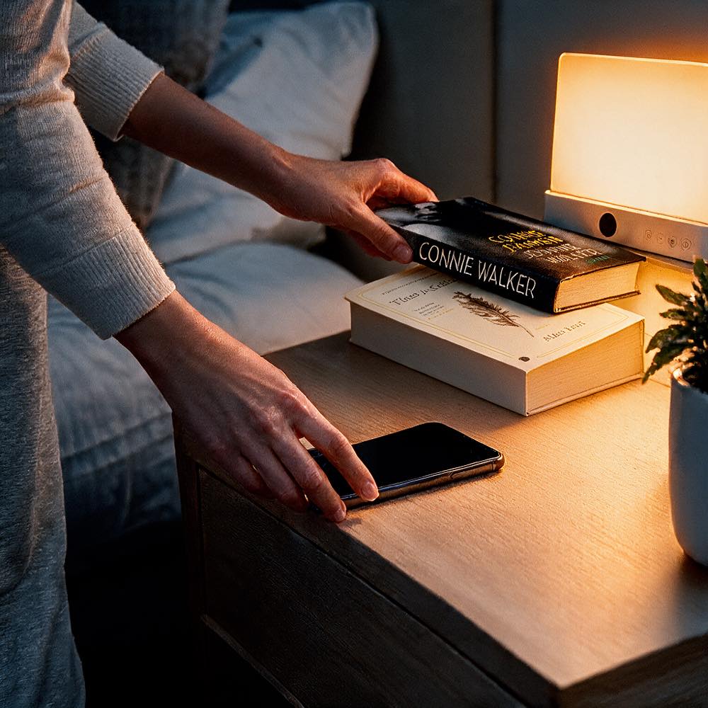Telefoon wegleggen en een boek pakken, met de Oogrust Leeslamp op het nachtkastje